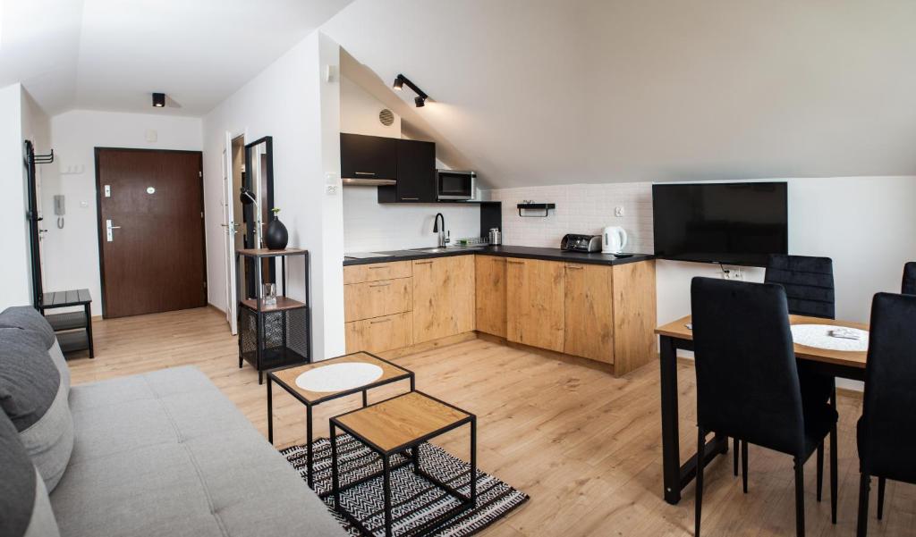 a living room with a table and a kitchen at Apartament Władysławowo in Władysławowo