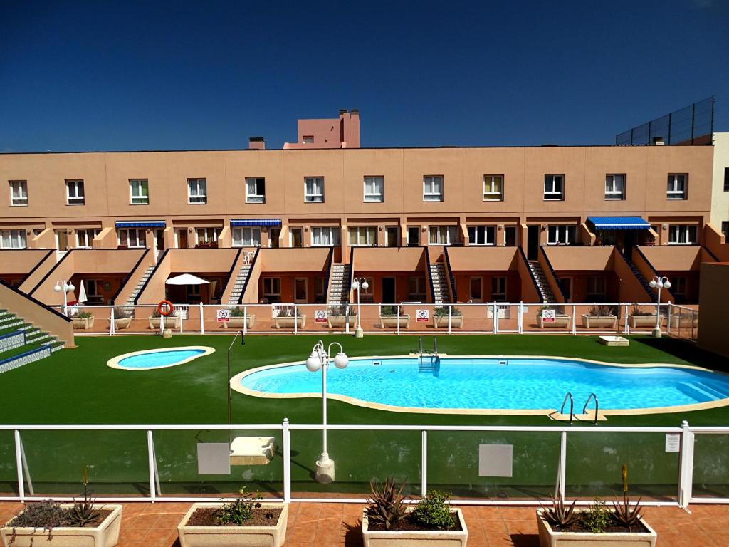 a hotel with a large pool in front of a building at Casa Paula in Corralejo