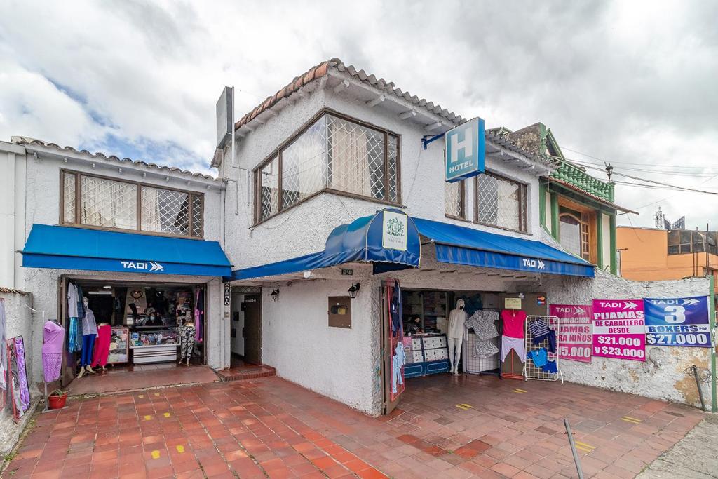 a store with blue awnings on the side of a building at Casa Hotel Victoria in Bogotá