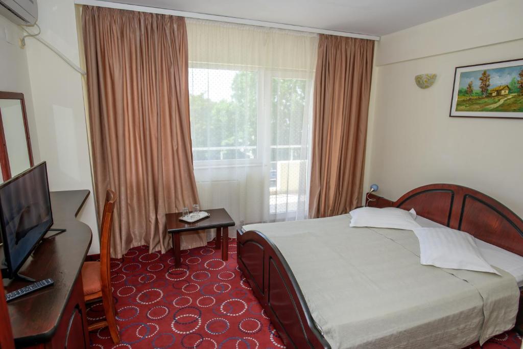 a hotel room with a bed and a window at Hotel Scala in Constanţa