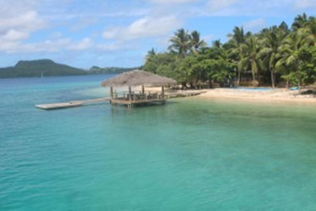 Tongan Beach Resort في Utungake: جزيرة صغيرة بها كوخ على الشاطئ