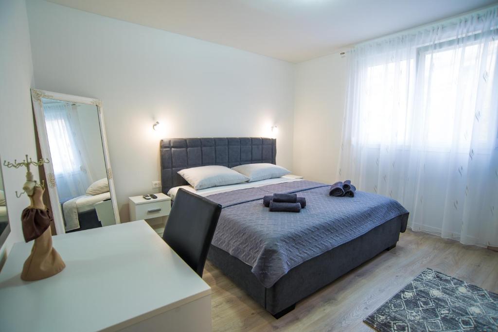 1 dormitorio con 1 cama con manta azul y espejo en Too Sweet Apartment 1, en Split