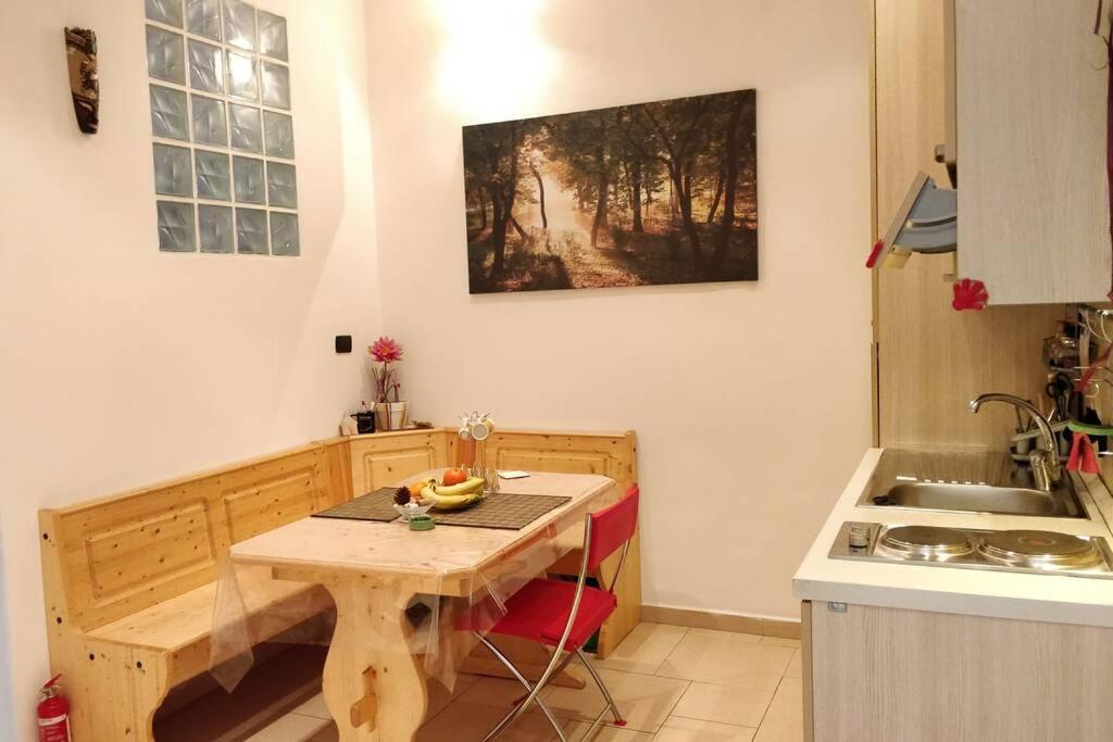 una pequeña cocina con mesa de madera y fregadero en Letto ad acqua H2OME, en Bari