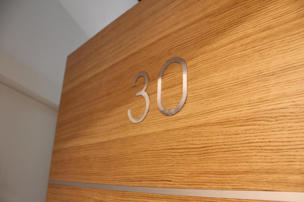 een houten klok met het nummer erop bij Wellport30 in Belgrado