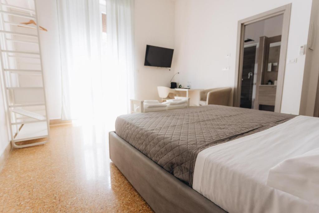 a white bedroom with a bed and a chair at THE NEST - Luxury suites in Pescara