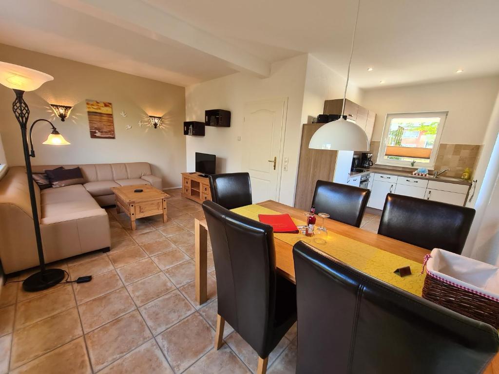 a dining room and living room with a table and chairs at Ferienhaus Dünenkieker in Kellenhusen