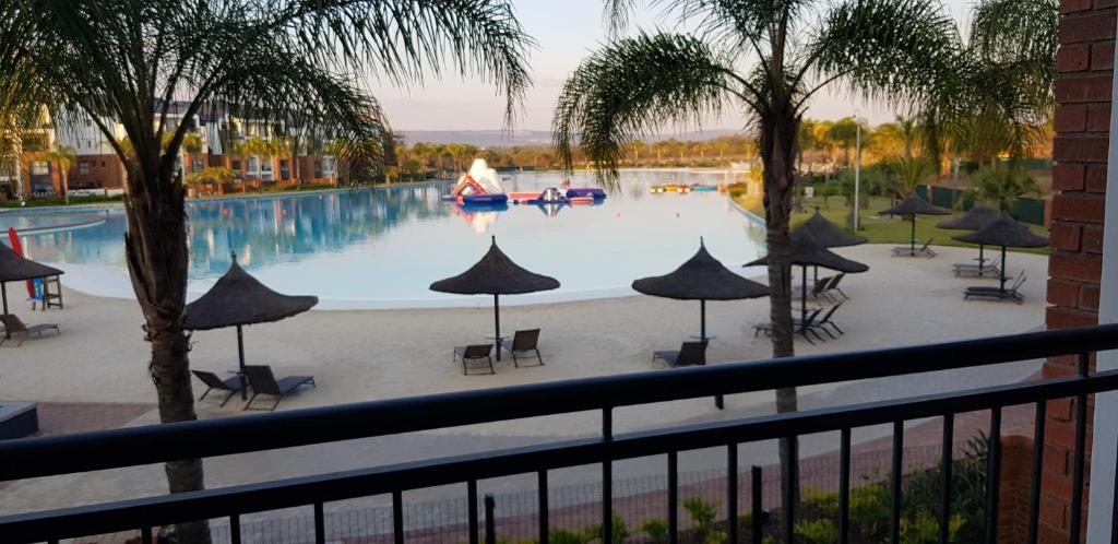 einen Balkon mit Poolblick in der Unterkunft Blyde Lagoon View Apartment in Pretoria