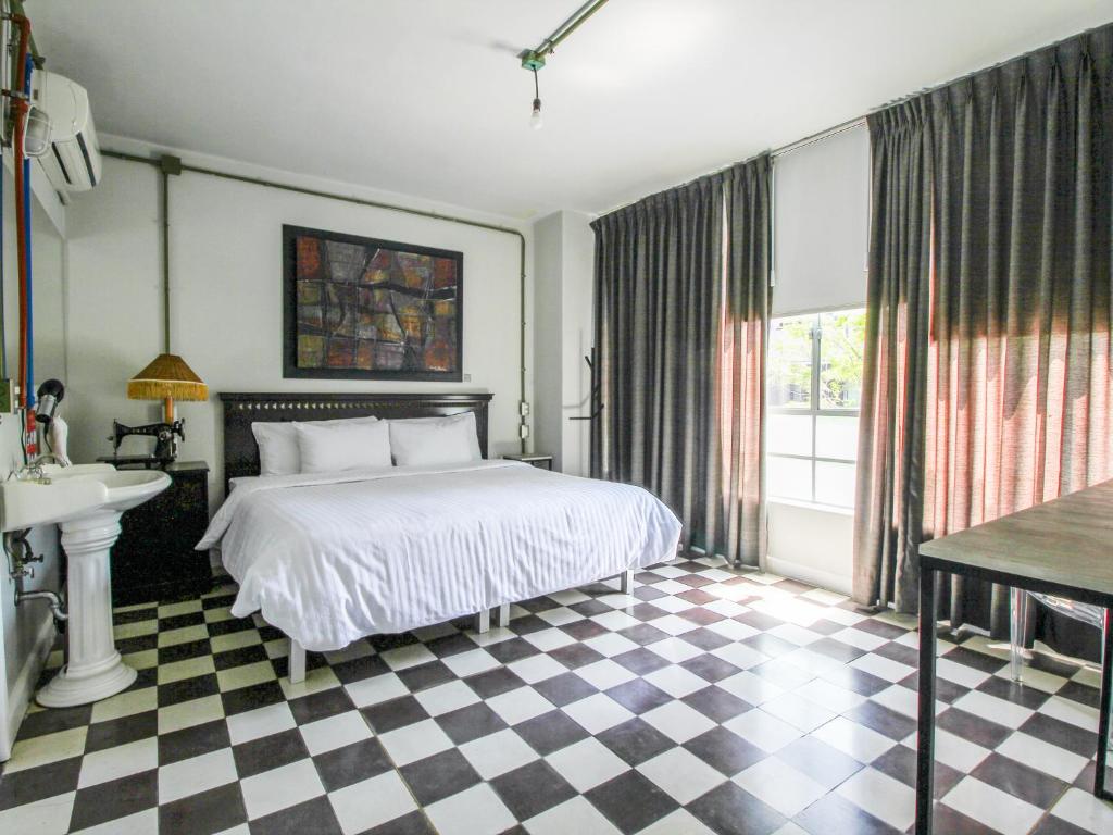 ein Schlafzimmer mit einem Bett und einem karierten Boden in der Unterkunft VL Hotel Boutique by Rotamundos in Guadalajara