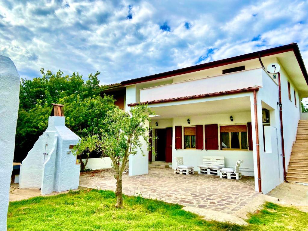 a small white house with a patio in front of it at Pineta sul mare S'Ena e Sa Chitta in Santa Lucia
