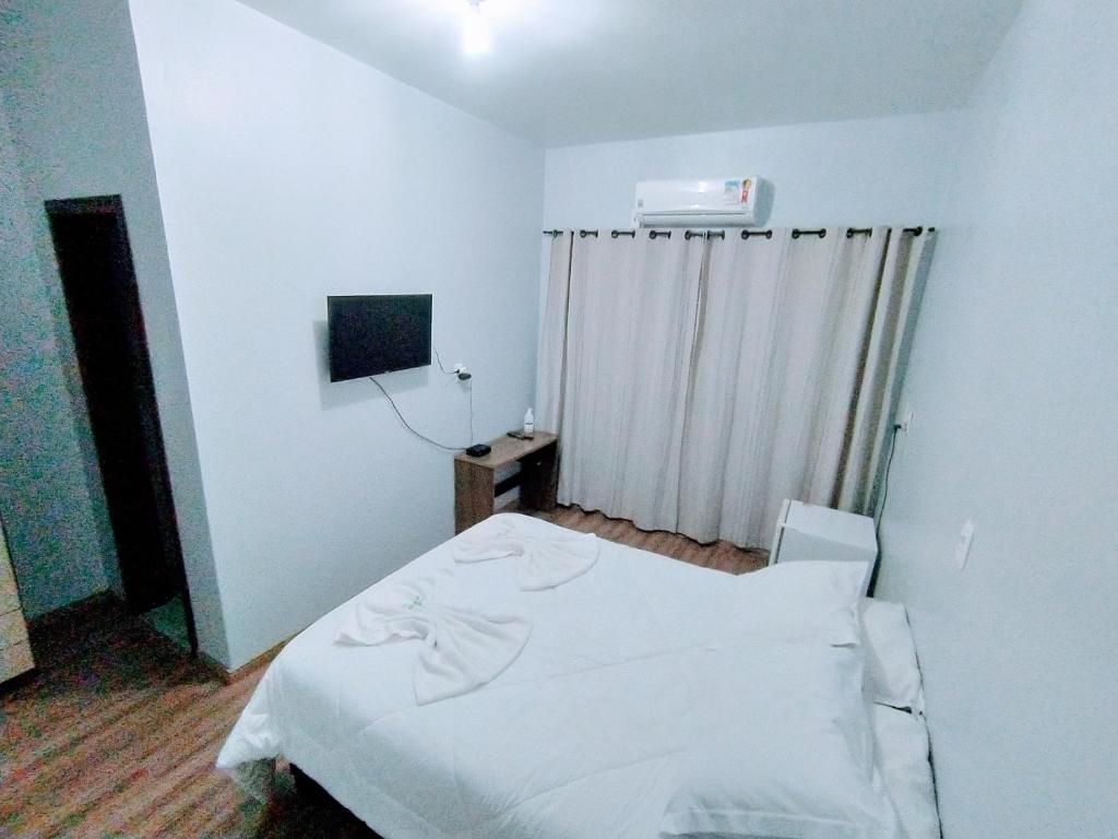 a hospital room with a white bed and a window at Pousada Aparados in Cambara do Sul