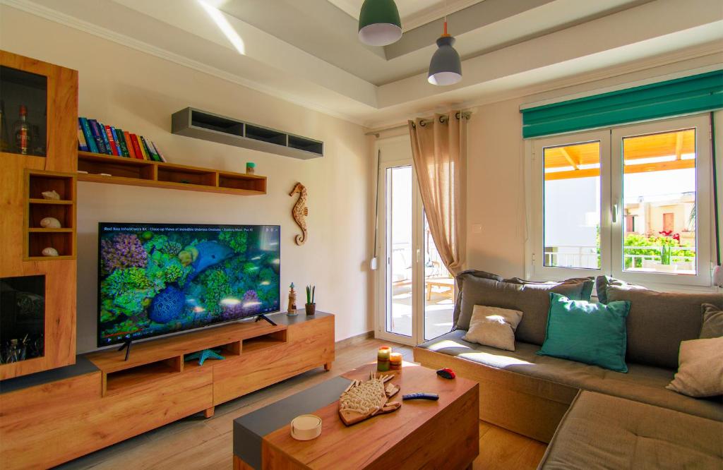 a living room with a large flat screen tv at Bitsakis Family II - Paleochora Luxury House in Palaiochora