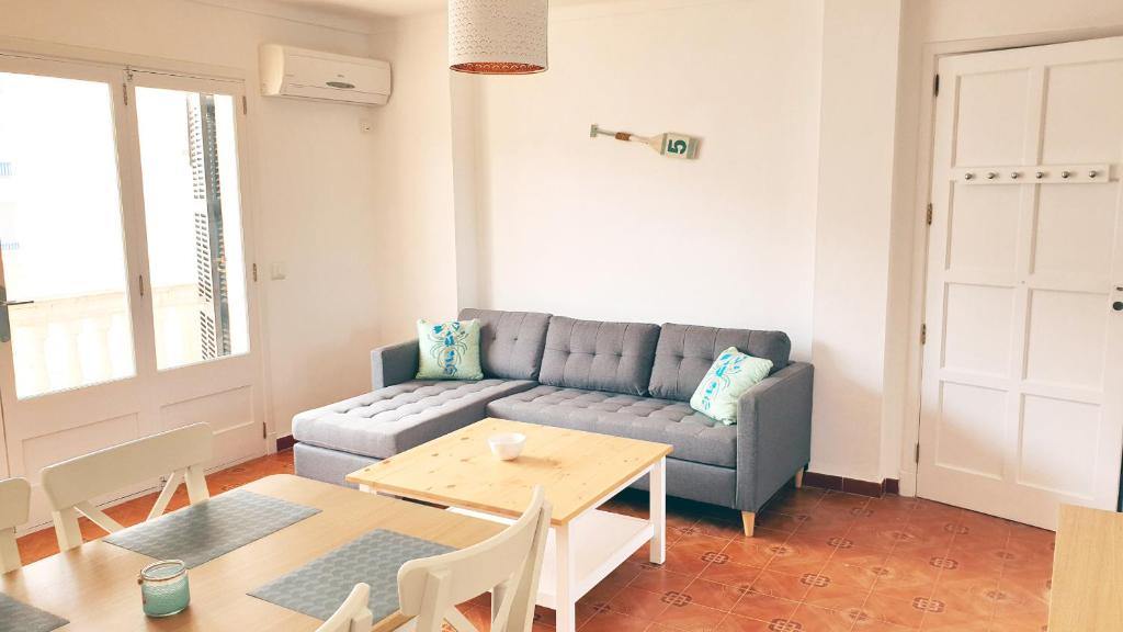 een woonkamer met een bank en een tafel bij Apartamentos Loremar in Portocolom