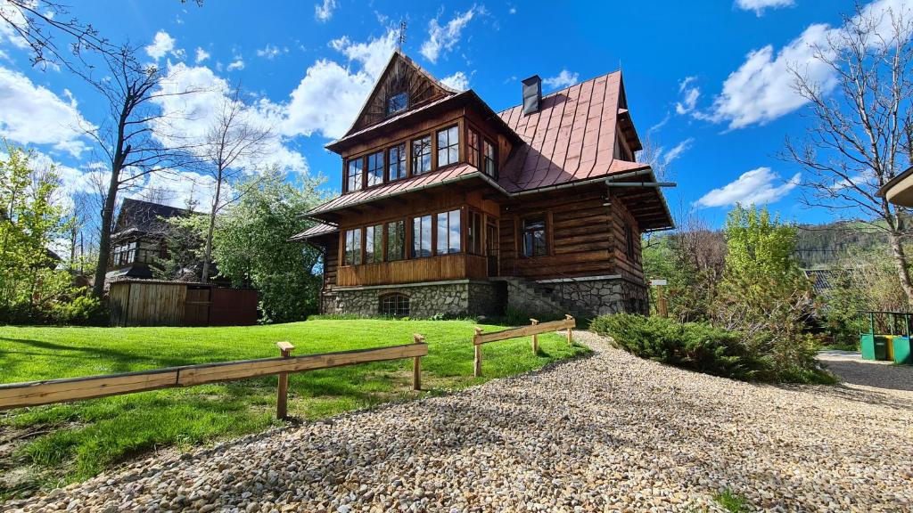 a large wooden house with a fence in front of it at Willa Rawa in Zakopane