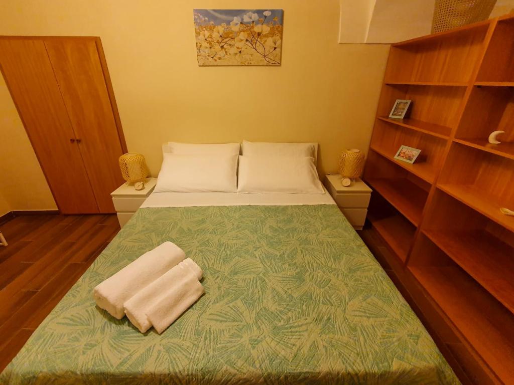 een kleine slaapkamer met een bed met twee handdoeken erop bij GE Suite in Catania