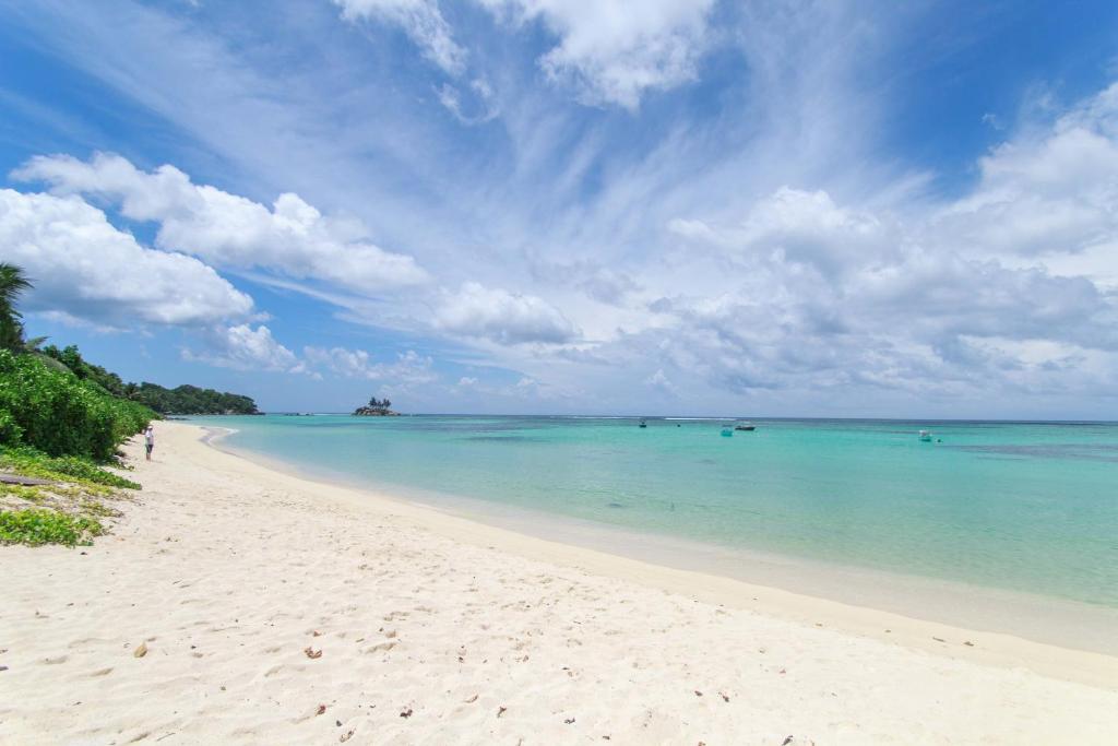 - une plage d'eau turquoise et un ciel nuageux dans l'établissement Coco Blanche, à Anse Royale