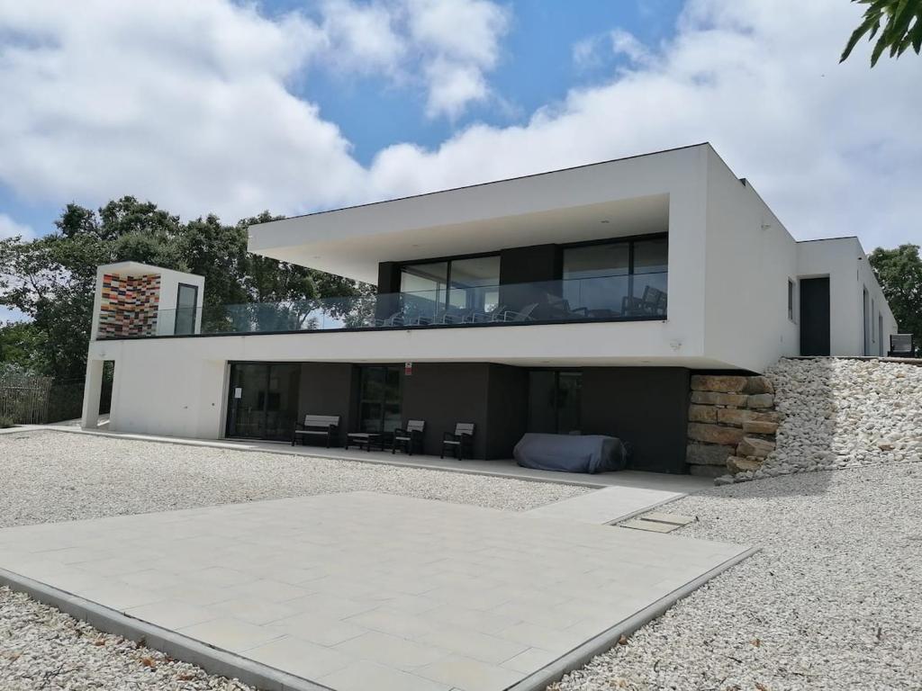 una gran casa blanca con muchas ventanas en Villa Casa Tranquilespiral Alcobaça-Nazare en Mendalvo