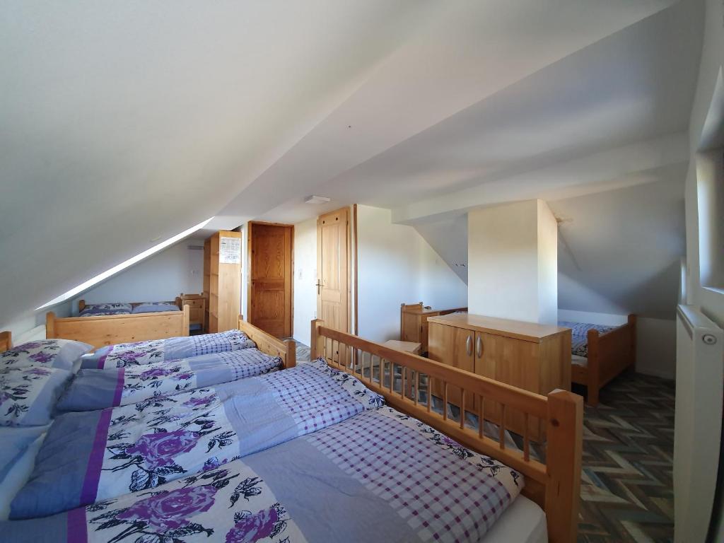 un dormitorio en el ático con 2 camas y una escalera en Pr` Florjan, en Cerklje na Gorenjskem