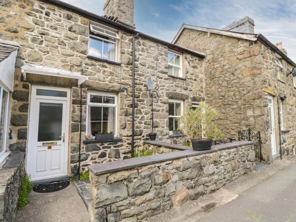 an old stone house with a white door at 6 Smithfield Lane in Dolgellau