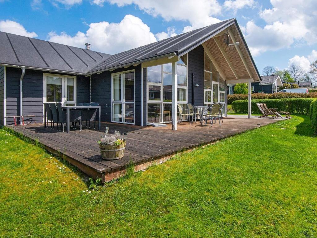 a house with a wooden deck in the yard at 12 person holiday home in Aabenraa in Loddenhøj