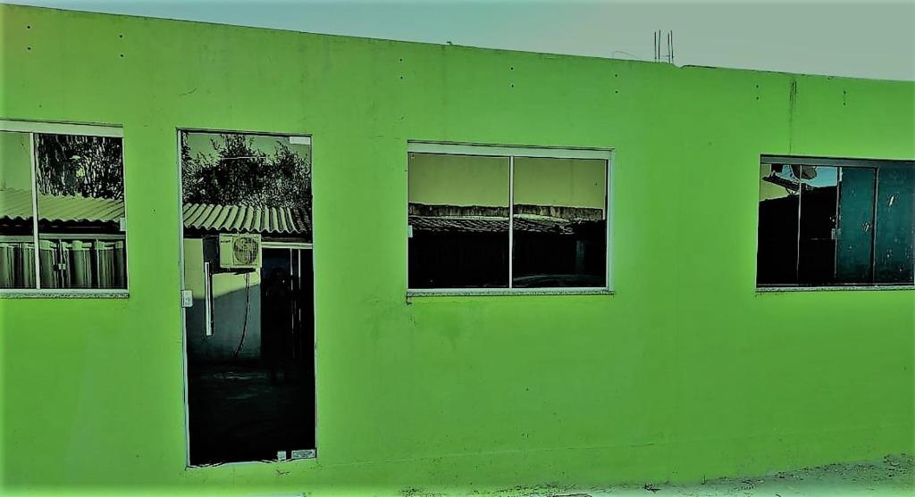 um edifício verde com janelas do lado em Pousada Vicenzi em Luziânia