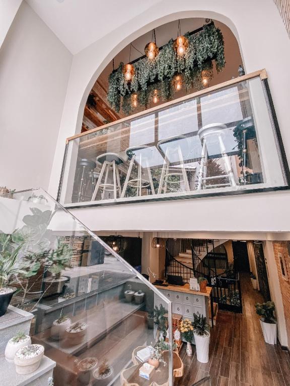 a glass staircase in a room with a table and chairs at Petite Dalat - Boutique Hotel in Da Lat