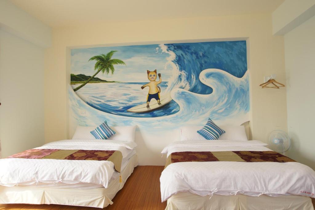 a room with two beds and a painting of a cat on a surfboard at 貓咪民宿Mini館-中午即可入房 in Taitung City