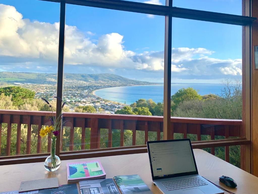 einem Laptop auf einem Tisch vor einem Fenster in der Unterkunft Kinoie Mornington - OCEANVIEW in Mount Martha