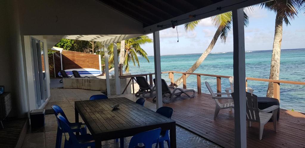 un porche con mesa, sillas y el océano en Arapati Holiday Homes, en Rarotonga