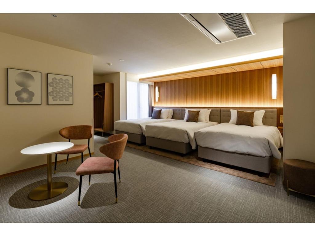 Habitación de hotel con cama, mesa y sillas en The OneFive Terrace Fukuoka - Vacation STAY 33435v, en Fukuoka