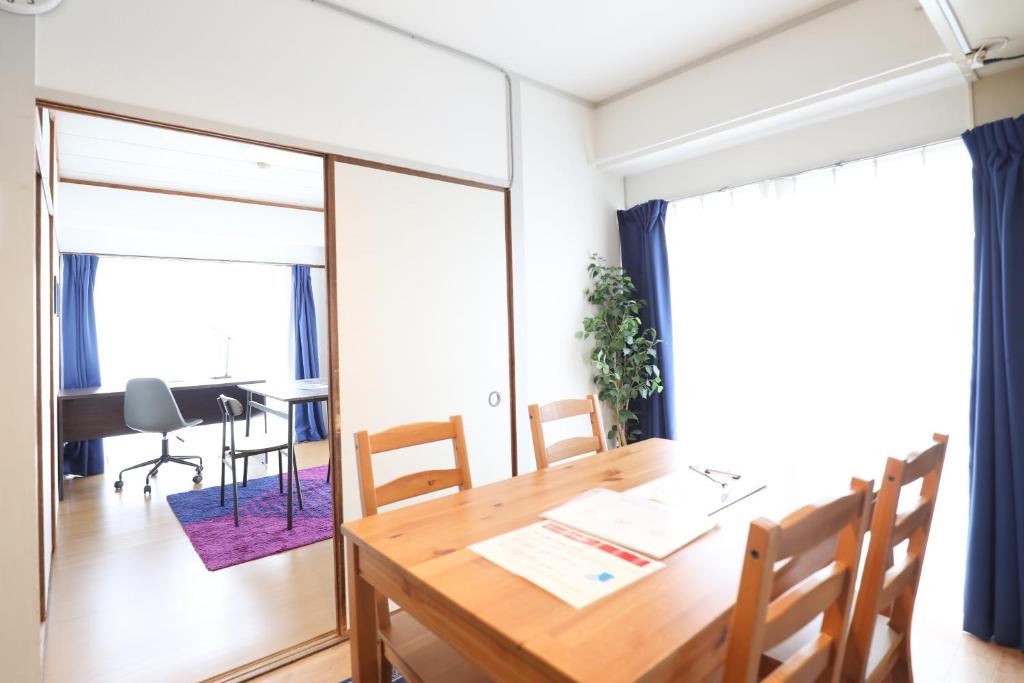 een eetkamer met een houten tafel en stoelen bij Reisen Apartment 603 in Fukuoka
