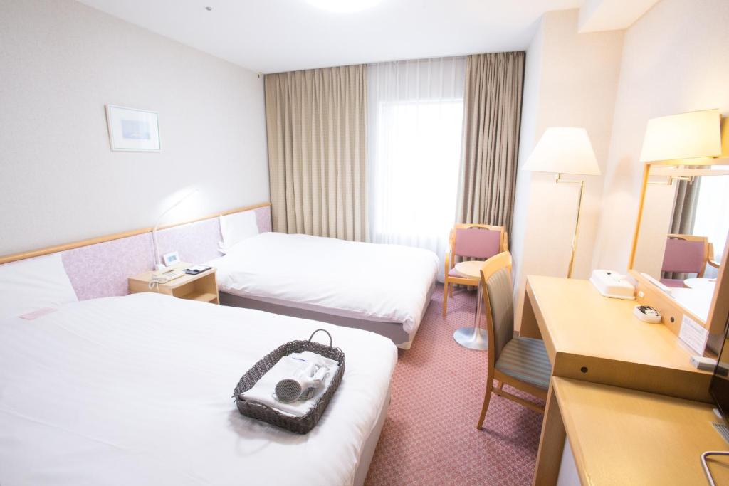 Postel nebo postele na pokoji v ubytování Toyama Chitetsu Hotel