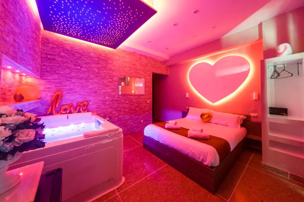 een roze slaapkamer met een bed en een bad bij Cleopatra in Rome