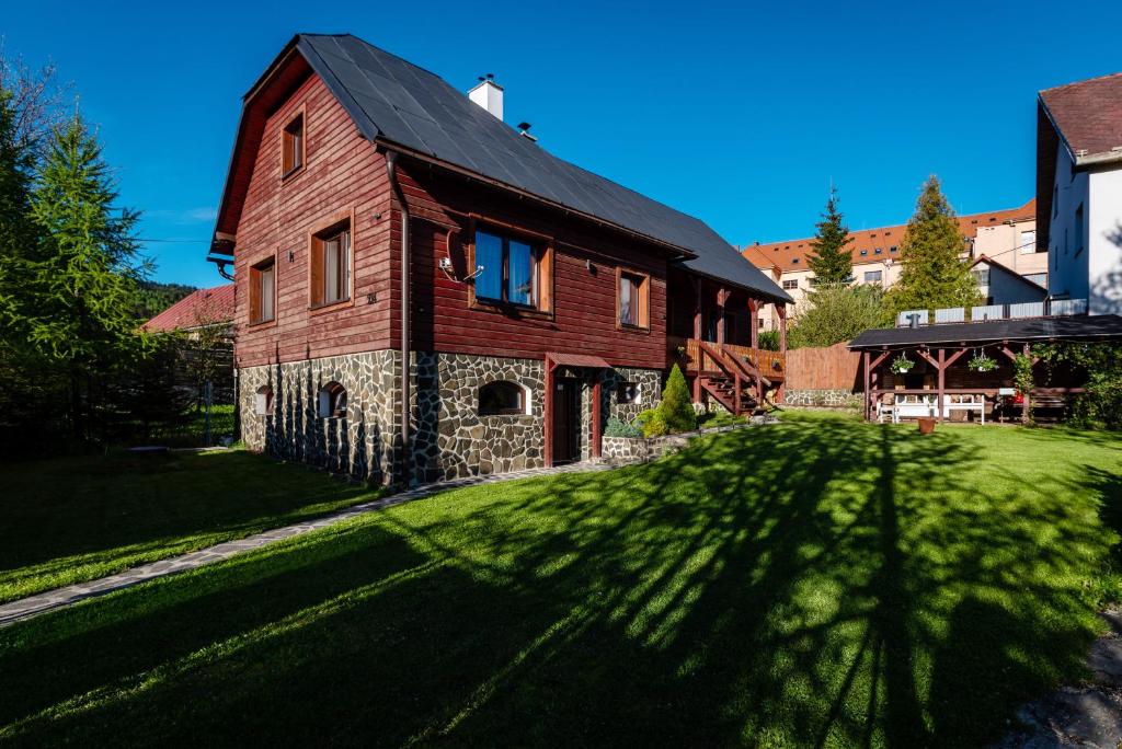 une grande maison en bois avec une grande pelouse dans l'établissement Chalupa Zubrik Telgárt, à Telgárt