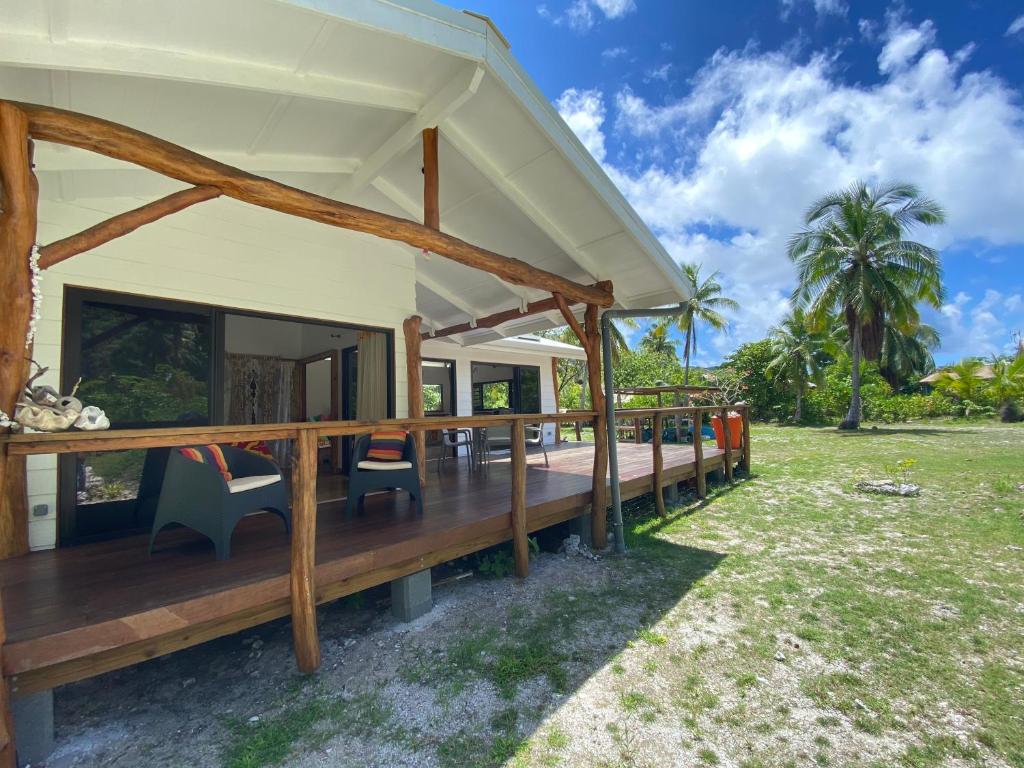 een huis met een veranda en stoelen in een veld bij Moorea Chill House And Beach in Teavaro