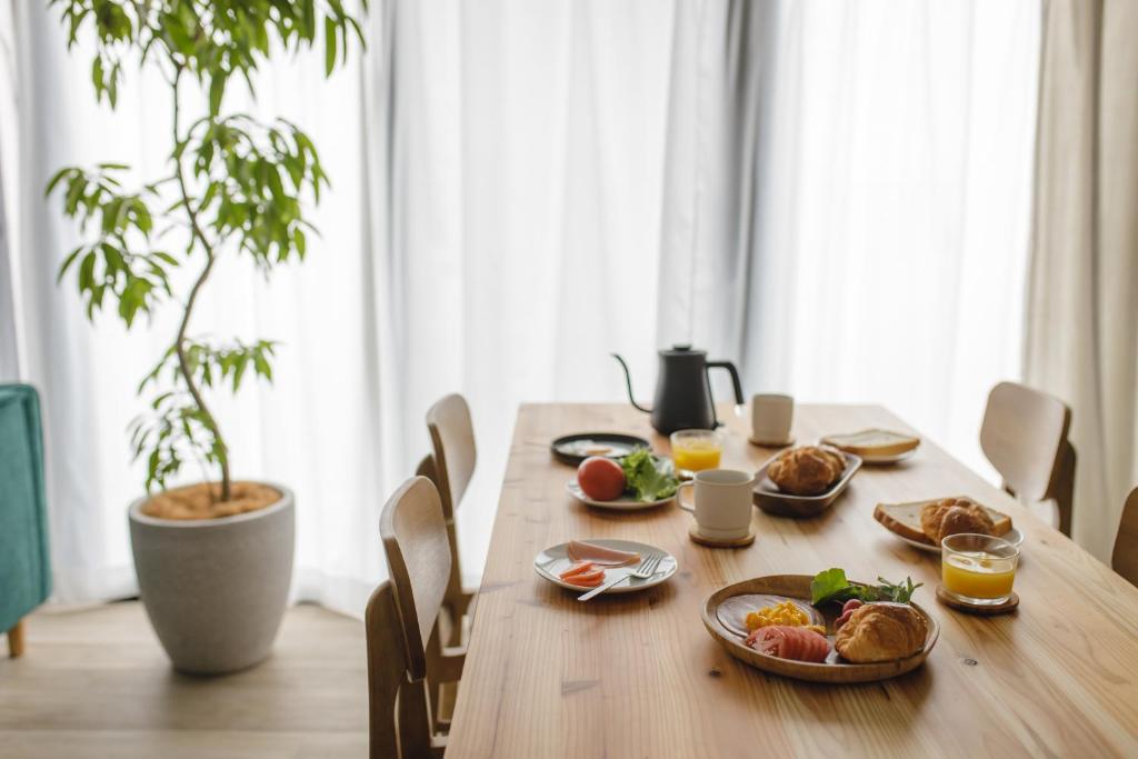 una mesa de madera con platos de comida. en THREE, en Tokio