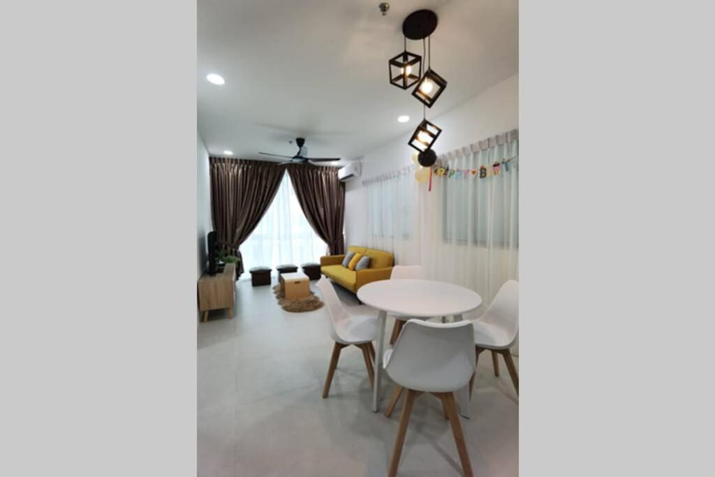 a living room with a white table and chairs at Jeff and Ricky Homestay Matang Metrocity in Kuching