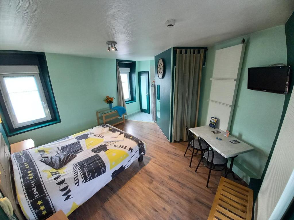 a bedroom with a bed and a table in it at Le Terminus fasthotel soissons centre in Soissons