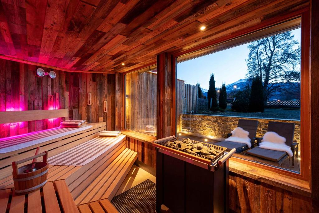 a sauna with a large window and a stove at Hotel Garni Schellenberg in Oberstdorf