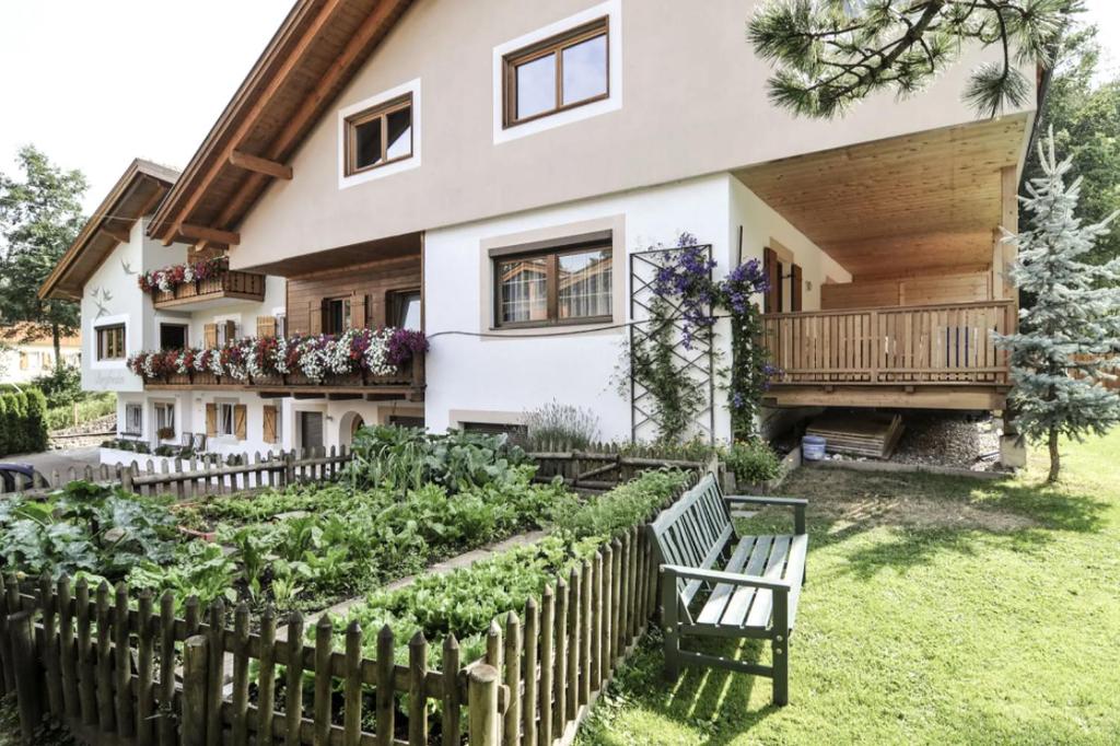 une maison avec un jardin en face dans l'établissement Bergfrieden Apartment 2 B, à Alpe di Siusi