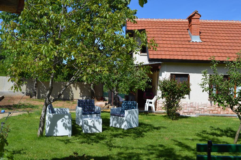 trois chaises assises dans l'herbe devant une maison dans l'établissement Macedonia, Accommodations,rentals"Villa Vevcani" Vevchani, à Vevčani