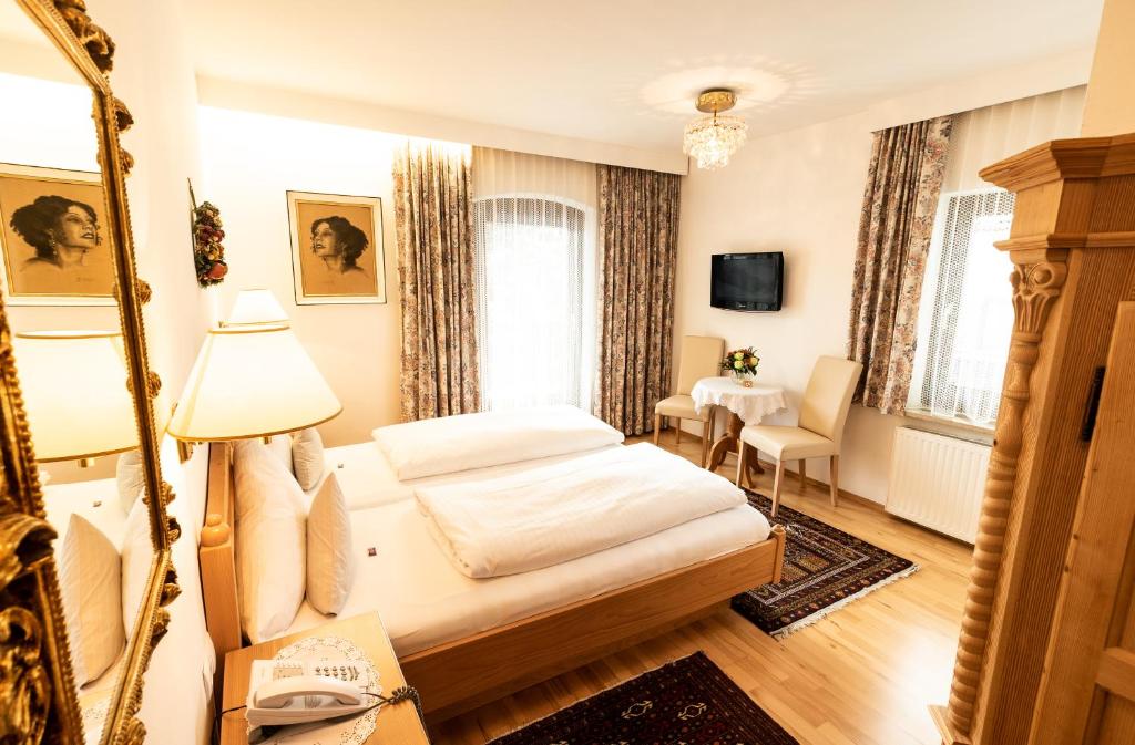 una camera d'albergo con un letto e una scrivania di Hotel Helga a Seefeld in Tirol
