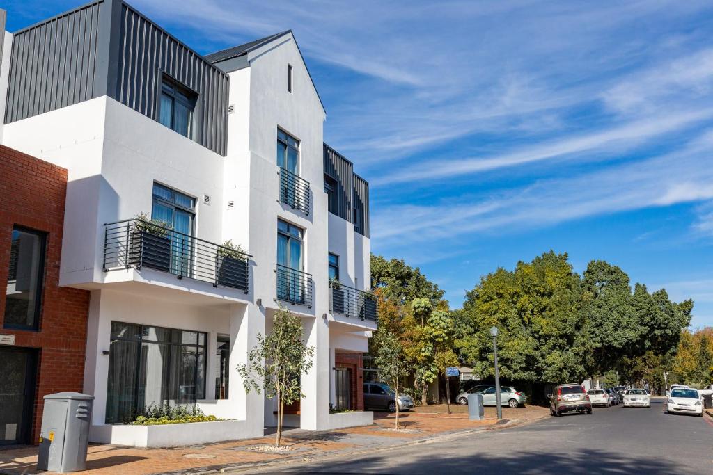 een wit gebouw aan de kant van een straat bij Hotel Krige in Stellenbosch