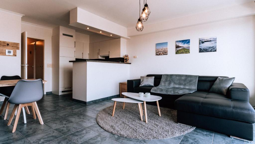 een woonkamer met een bank en een tafel bij Casa MaTi in Blankenberge
