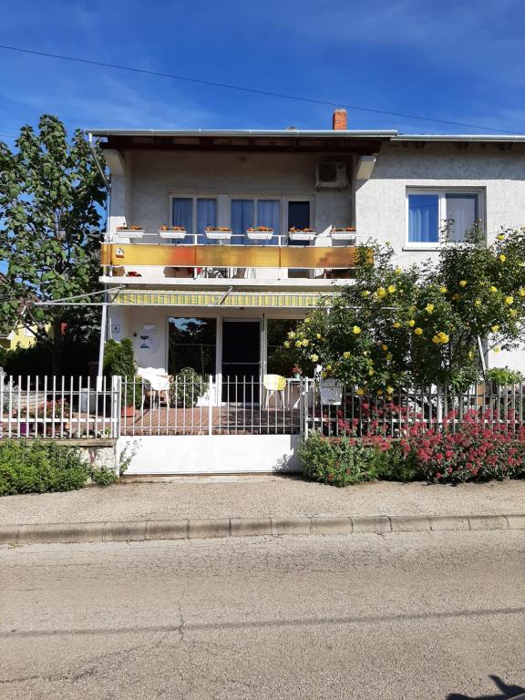 a white house with a fence in front of it at Sirokkó Apartman in Balatonfüred