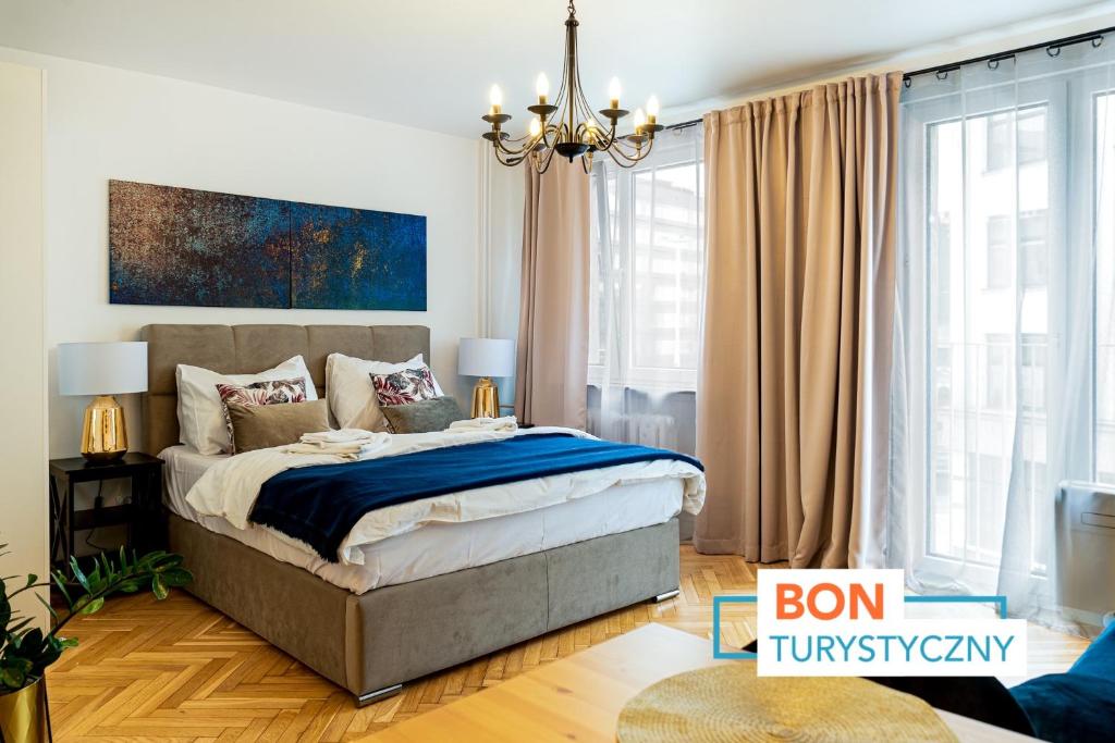 - une chambre avec un lit et un lustre dans l'établissement Apartament Oławska, à Wrocław
