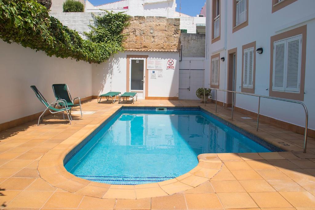 ein Schwimmbad in der Mitte eines Gebäudes in der Unterkunft Hotel Geminis in Ciutadella