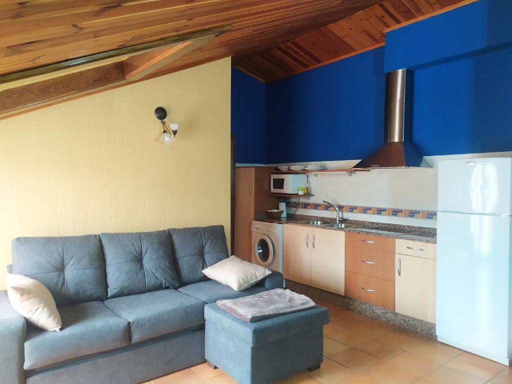 salon z niebieską kanapą w kuchni w obiekcie Tejadillos - Apartamentos El Cabo w mieście Las Majadas