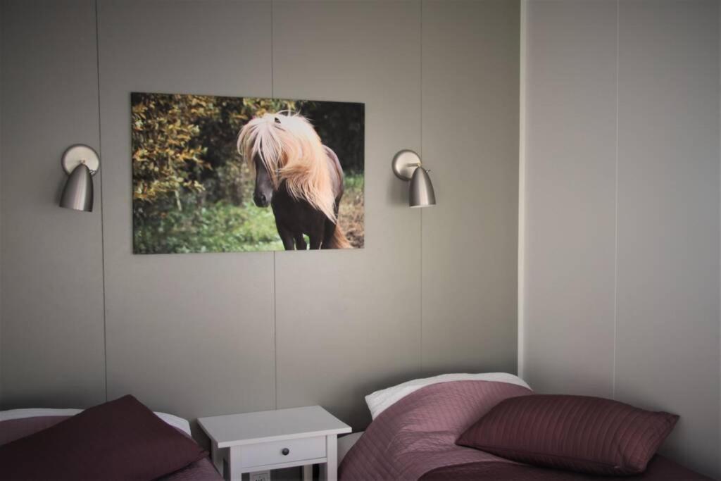 ein Wohnzimmer mit einem Pferdebild an der Wand in der Unterkunft Strýta Apartment 3 in Ölfus