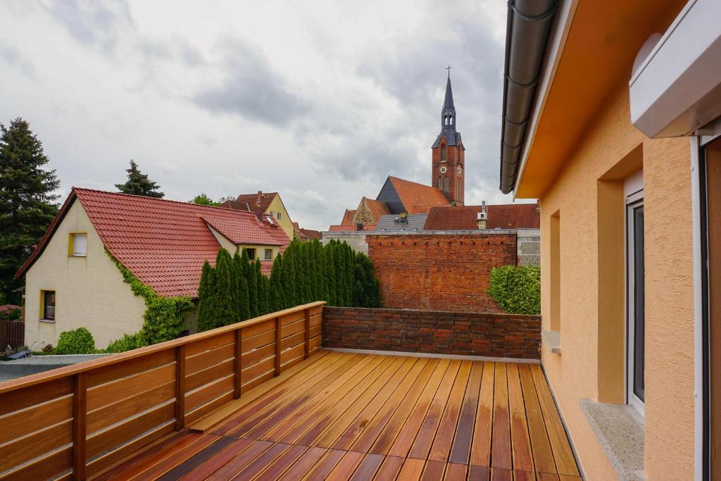 una terrazza in legno con vista sulla città di Ferienwohnung Kirchblick, für Familien, Freunde, keine Monteure a Gräfenhainichen
