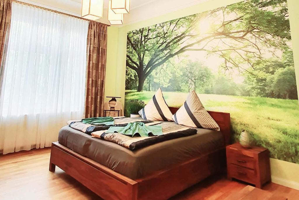 Schlafzimmer mit einem Bett mit Wandgemälde in der Unterkunft Luxus Ferienwohnung mit hochwertiger Ausstattung Wintergarten in Cottbus